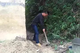 小伙子很喜欢农村土坯房，拿起锄头开沟排水，防止被雨水侵蚀破坏