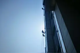 高空“蜘蛛人”：烈日下穿雨衣清洗 热伤了用水浇身体图片