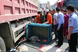 三轮车钻入大货车底：司机被压货车车轮下图片