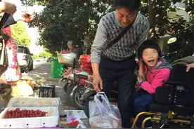 父亲带着脑瘫女儿街头摆摊 积攒些钱就四处求医治病图片