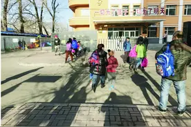 上下学众多家长扮演"书童" 老师建议:让孩子自己背书包 这是学习的一部分图片