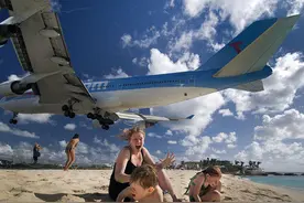 波音747飞机贴着游客头顶飞过海滩引围观图片