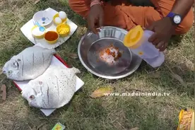 印度男子拎着两条鱼，河边清洗后稻田边生火油煎，好惬意的生活！图片