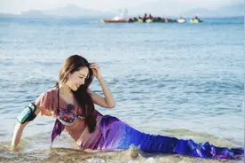 吉娜着美人鱼泳装凸显好身材，海边侧卧玩耍笑容灿烂图片