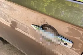 女子车门把手被涂不明液体，用手一摸黏答答，车窗上还有三个字图片