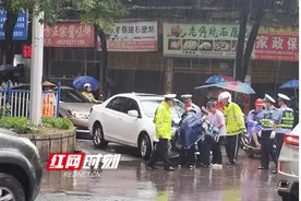 电动车雨中倒地，交警急忙帮助图片