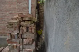 女子为寻狗被卡墙缝 消防队员破拆土墙救人图片