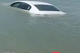 男子凌晨将车开到三亚湾沙滩上看海，涨潮后海水将车淹没一半图片