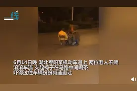 危险！两老人深夜在马路中间支椅喝茶，过路车辆纷纷减速避让图片