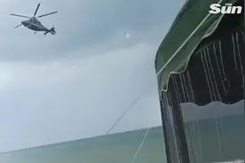 乌克兰一架直升机把海滩上的露营设备吹飞 男孩险被遮阳伞砸中图片