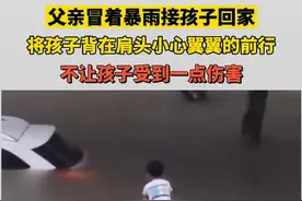 父亲冒着暴雨接孩子回家，将孩子背在肩头，小心翼翼的前行图片