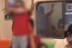 上海一男孩在地铁上爬扶手杆荡秋千，家长不制止，还鼓励他往上爬图片