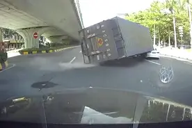 吓人！货车调头失控侧翻 货厢瞬间将一行驶中轿车后部压扁图片