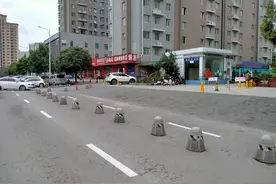 郑州一小区门口10多个石墩圈占半条路，物业：不占的话别人就占了图片