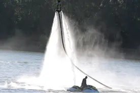 沈阳浑南夕阳下水上飞行爱好者在摩托艇的伴随下喷着水幕自由飞翔图片