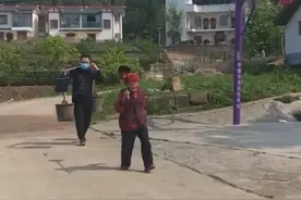 哭笑不得！四川一男子回老家拿着公文包，一边接电话一边挑粪担图片