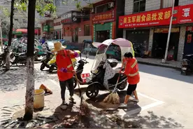 新干环卫工头上撑起爱心伞，笑开了花图片