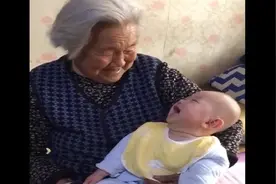 老奶奶抱着重孙子笑的合不拢嘴，一个小动作值得称赞~