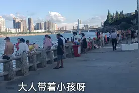 湖南衡阳湘江边，有地摊一条街，很多年轻男女在江里游泳，很热闹