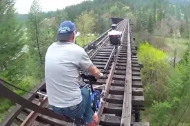 国外大爷在铁路高架桥上骑自行车，大家说这胆量谁能比视频封面