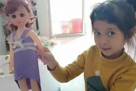 用纸给她的娃娃做衣服，感觉她很有服装设计师的天赋！