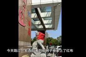 酒店门前的石狮子为什么会被蒙上红布？