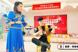 塔城市的鄂温克族小伙子用哈萨克族民族乐器冬不拉弹奏了一曲