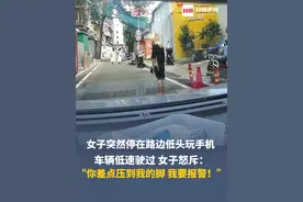 女子突然停在路边低头玩手机，车辆低速驶过，女子怒斥：你差点压到我的脚，我要报警！