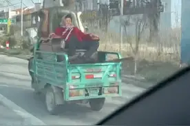 大爷骑三轮载大妈，大妈坐移动大沙发，网友:这是赶着去上朝吧！图片