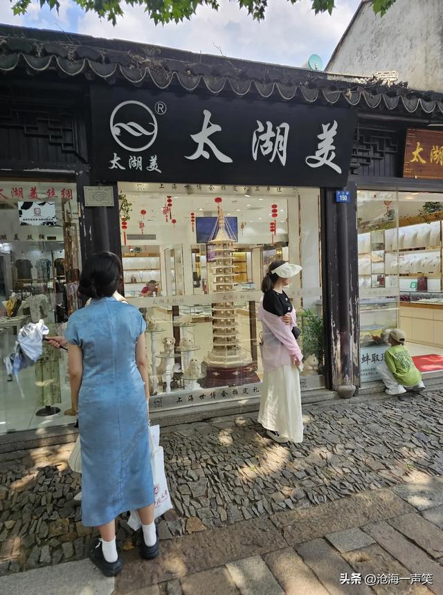 平江路打伞避暑的姑娘，平静的河水，悠悠的乌篷船，悠久的历史