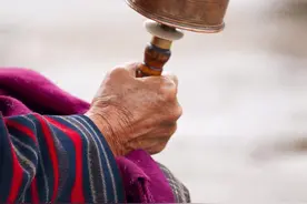 西藏人拿着转经筒的时候口里含的是什么？图片