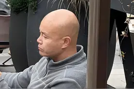 50岁乐嘉定居云南，坐在路边看手机，牵着大狗，生活非常休闲惬意图片