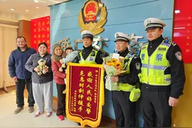 跟着妈妈向救命恩人赠送锦旗，获救男孩凡凡抱着韩靖亲不够图片