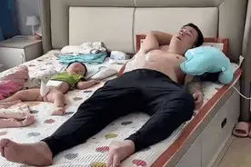 爸爸跟孩子睡觉的时候细心地准备了保护措施图片