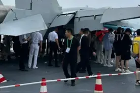 7月5日，山东舰开放参观时突遇降雨，观众纷纷躲进歼-15T机翼下方避雨。这一幕让人想起2024年第十五届中国航展遭遇大雨，游客也是躲在歼-15T下避雨，中国战机永远为人民遮风挡雨具象化了！