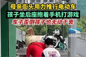 7月16日，江苏无锡。母亲街头用力推行电动车，孩子坐后座抱着手机打游戏，车子歪倒孩子也无动于衷视频封面
