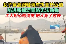 11月8日，浙江杭州。女子穿高跟鞋骑车执意抄近道，陷进新铺沥青路无法动弹。工人担心她烫伤，把人背了过去视频封面