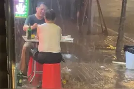 两男子在大雨里把酒言欢，网友：喝的不是酒，是故事图片