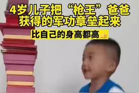 4岁儿子把“枪王”爸爸获得的军功章垒起来，比自己的身高都高图片