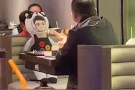 老人独自与玩偶吃自助餐，每吃一个新菜都抬头看一眼。愿每个老人都能有所陪伴，愿他们不再感到孤单图片