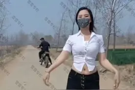 女子在马路中间跳舞，路过的大爷停下来观看，迟迟不愿离去图片