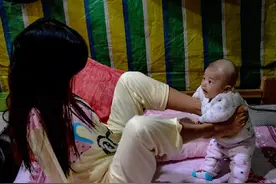 没有双臂的80后母亲，靠双腿哺乳，用双腿换尿布养活两个女儿图片