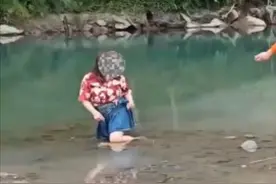 四川成都：一女子涉水乘凉时，不慎双脚陷入淤泥无法自拔图片