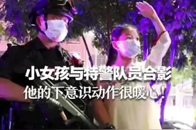 小女孩与特警队员合影，特警队员下意识的动作很暖心图片