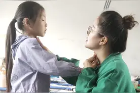 语文老师教听障女孩摸喉咙练习发声图片