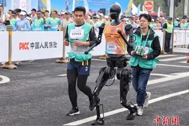 全球首个人形机器人半马上，陪跑员跟着机器人随时紧螺丝，1.2米的“旋风小子”没能跑赢1.8米的大高个图片