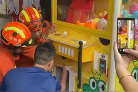 娃娃机卡住了个真娃娃，不哭不闹淡定玩耍，消防员赶来助他脱困图片