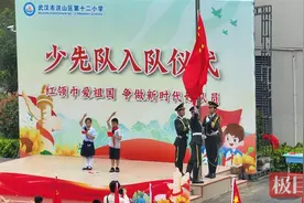 大手牵小手！大学生与小学生一起升国旗图片