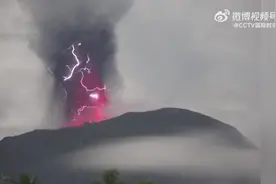 印尼伊布火山喷发，火山口周围闪烁紫色闪电图片