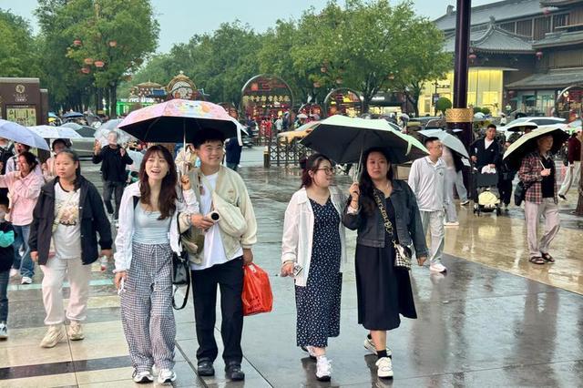 漫步不夜城 雨天游客热情不减
